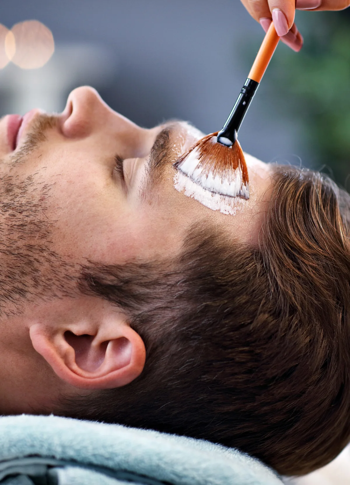 Facial mask being applied to a man’s forehead