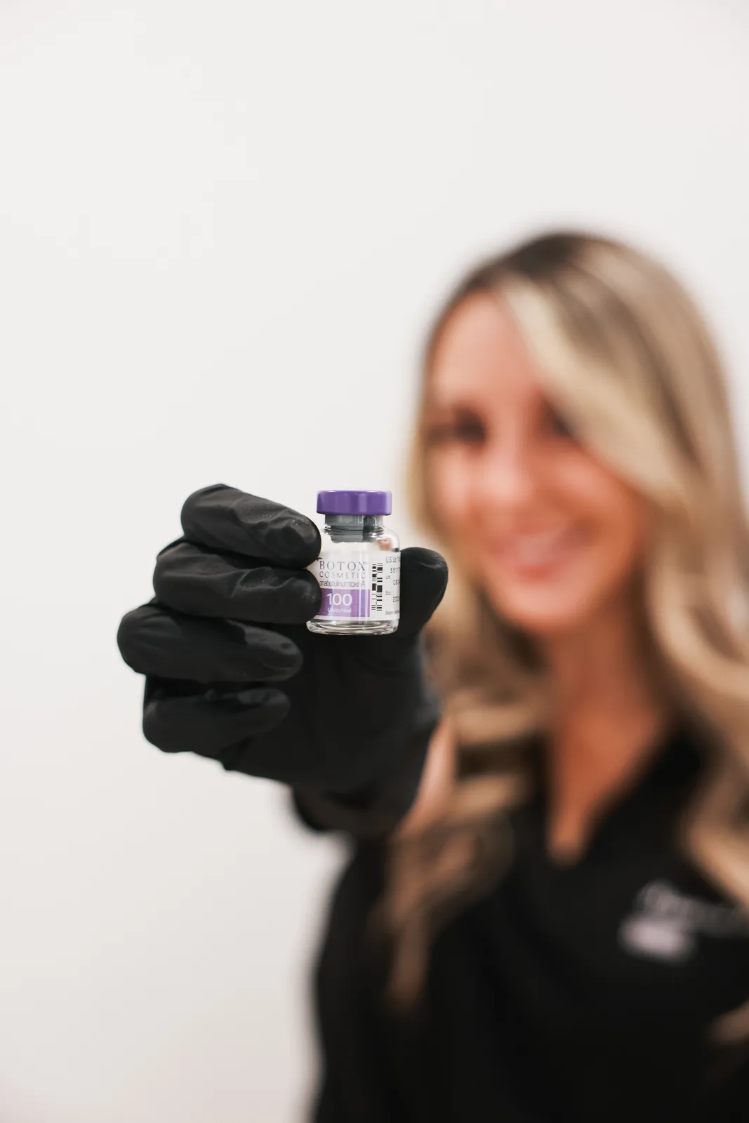 Advanced Aesthetics team member holding a vitamin vial